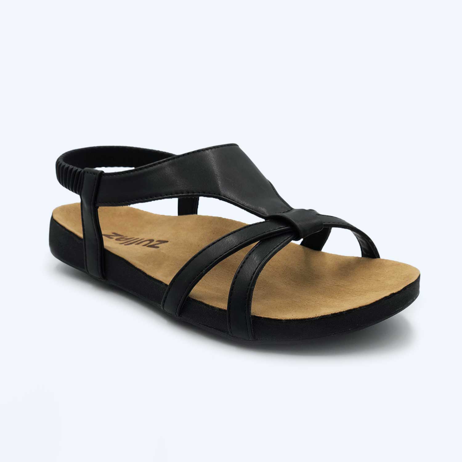 The Anna – Black sandal features a tan cushioned footbed, open toe, elastic heel strap, and crisscrossing black straps over the front and sides.
