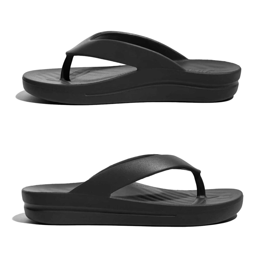 Two TIKI – Black thong-style sandals with thick soles are displayed side by side on a white background, both in a side view.
